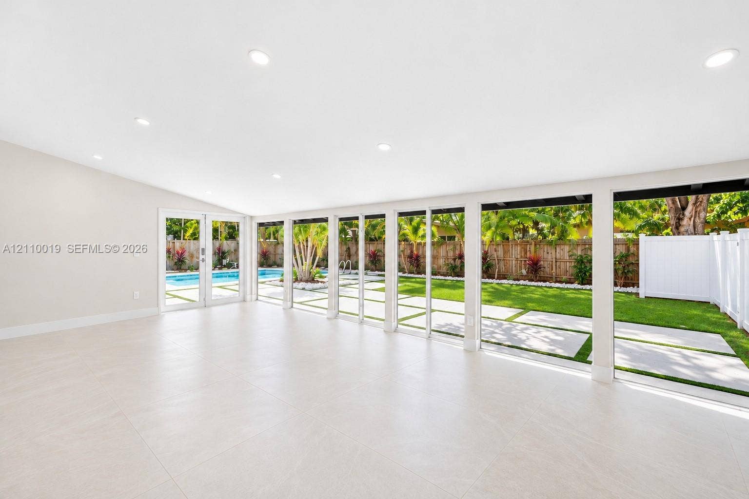1708 SW 11th Street, Fort Lauderdale, Fort Lauderdale, FL 33312 Open-concept interior featuring large-format tile flooring, recessed lighting, and expansive floor-to-ceiling glass panel doors