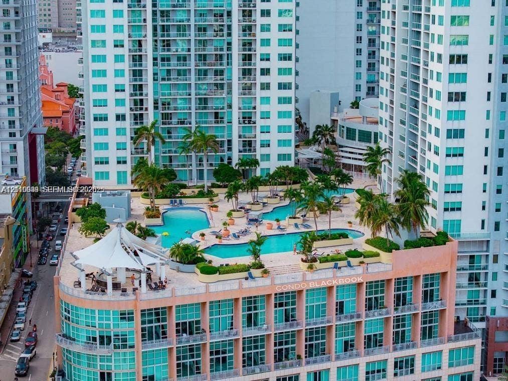 244 Biscayne Boulevard, #301, Miami, FL 33132 Elevated terrace featuring a multi-level swimming pool, integrated landscaping with mature palm trees, and a permanent tension-fabric shade structure