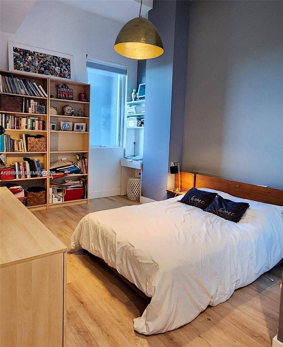 244 Biscayne Boulevard, #301, Miami, FL 33132 Wood-finish flooring, dome-style pendant lighting, built-in shelving, and a custom wood headboard