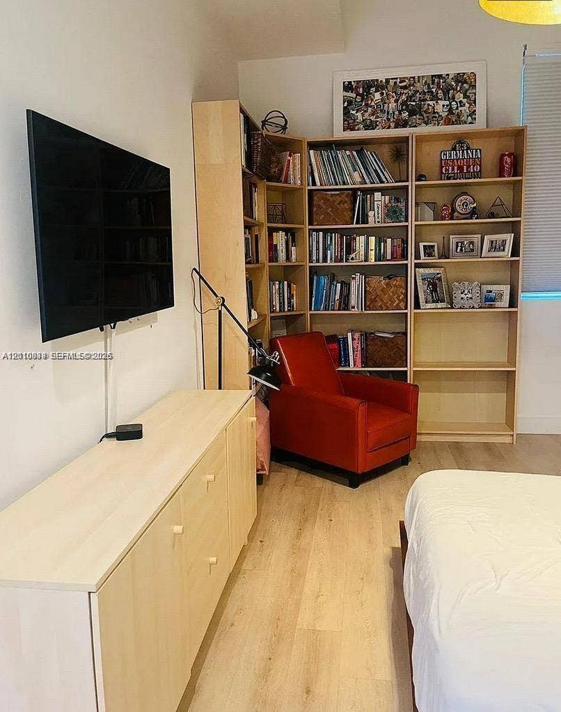 244 Biscayne Boulevard, #301, Miami, FL 33132 Built-in light-wood shelving unit with corner configuration, smooth wood-finish flooring, and wall-mounted television console with cabinets