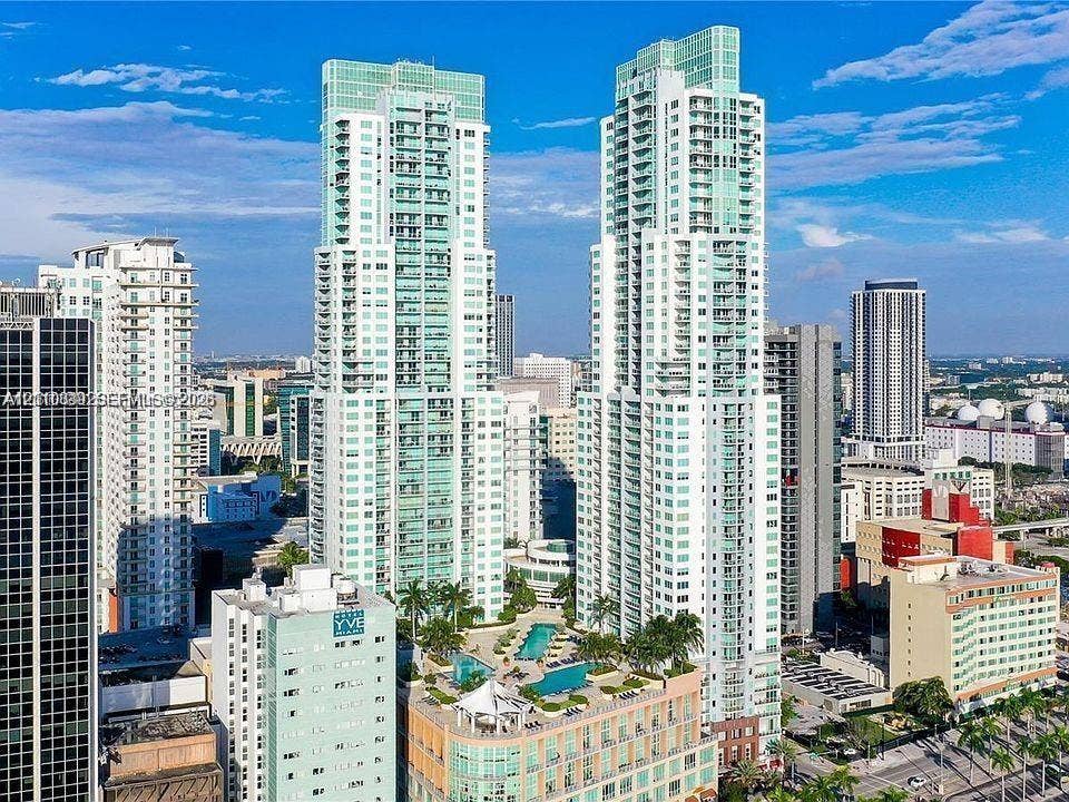 244 Biscayne Boulevard, #301, Miami, FL 33132 High-rise residential towers featuring glass-facade architecture, private balconies, and an elevated podium terrace with a swimming pool