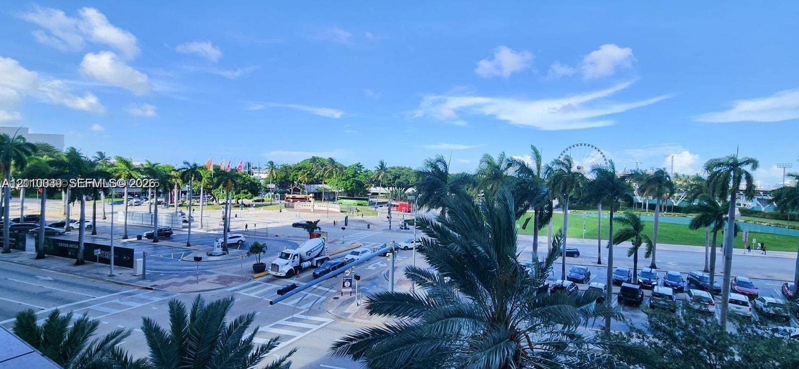 244 Biscayne Boulevard, #301, Miami, FL 33132 Elevated exterior perspective featuring mature palm trees, paved parking areas, and expansive open green space