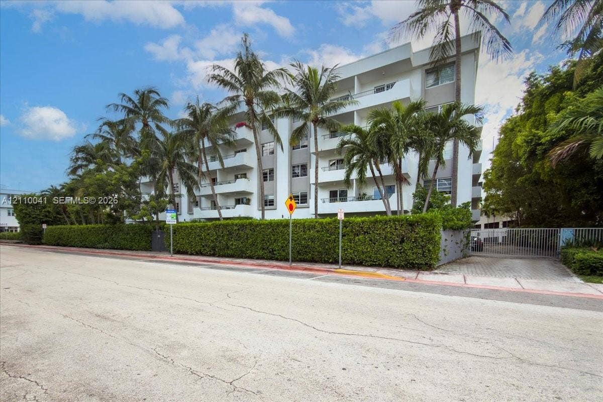 1610 Lenox Avenue, #516, Miami Beach, FL 33139 Multi-story building featuring private balconies, a gated entrance, and landscaped perimeter hedging