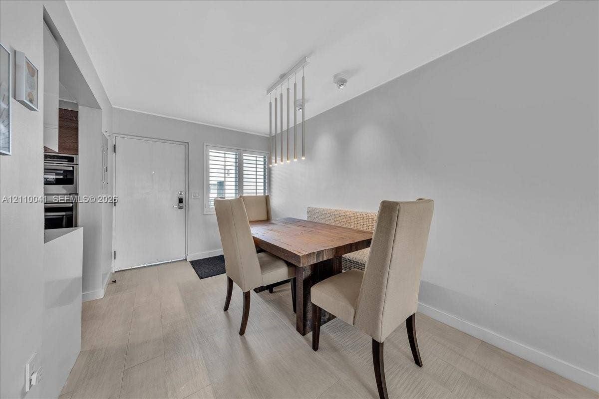 1610 Lenox Avenue, #516, Miami Beach, FL 33139 Wood-finish flooring, multi-pendant linear light fixture, and window shutters