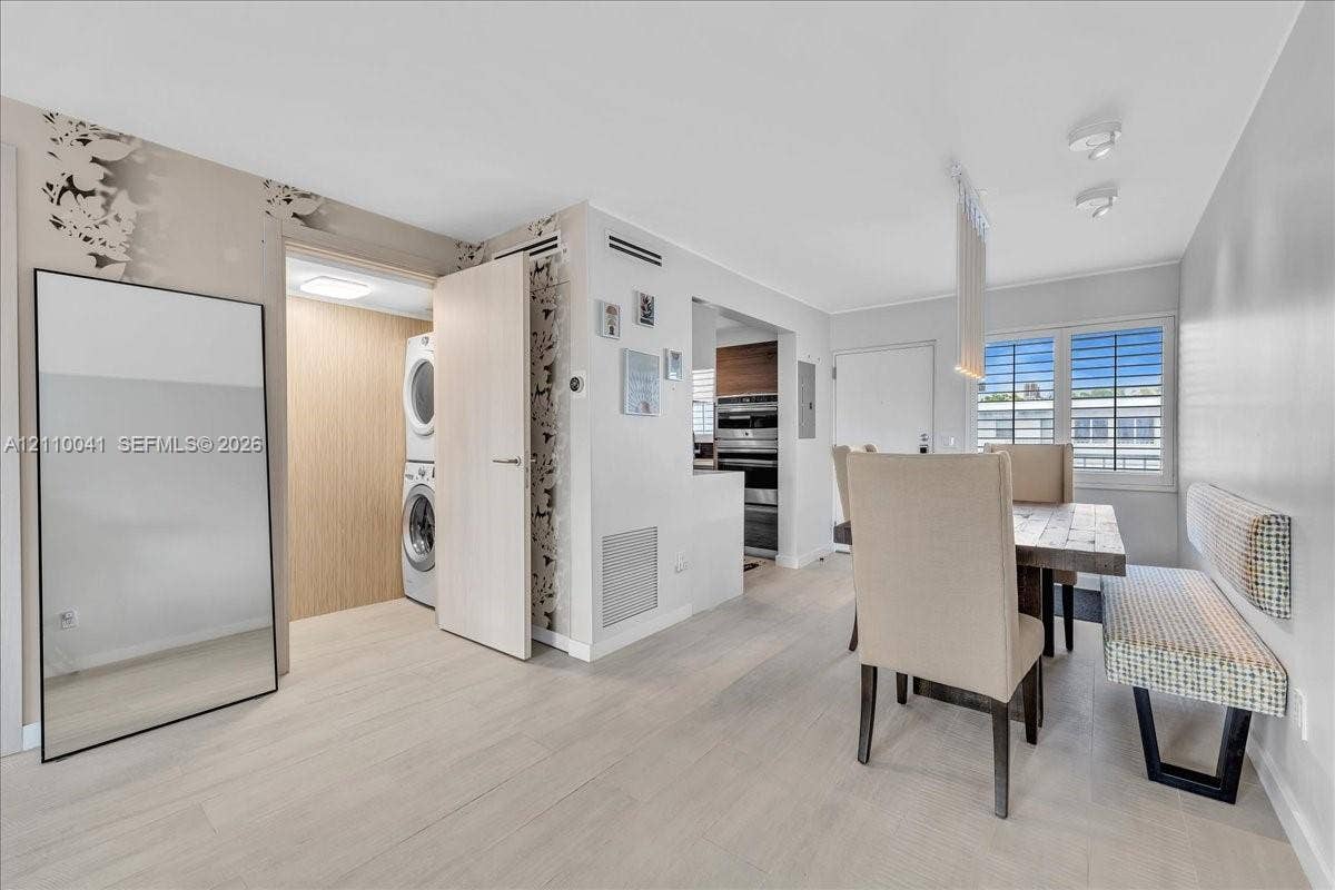 1610 Lenox Avenue, #516, Miami Beach, FL 33139 Light-toned wood-finish flooring, dedicated laundry closet with stackable appliances, recessed ceiling lighting, and windows with horizontal blinds