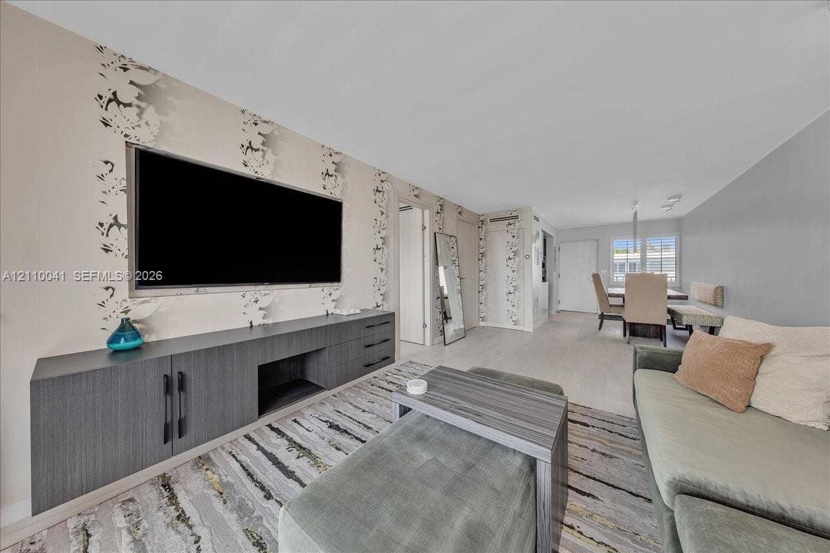 1610 Lenox Avenue, #516, Miami Beach, FL 33139 Living area featuring custom charcoal-finish built-in cabinetry, patterned wallpaper, light-toned flooring, and recessed lighting