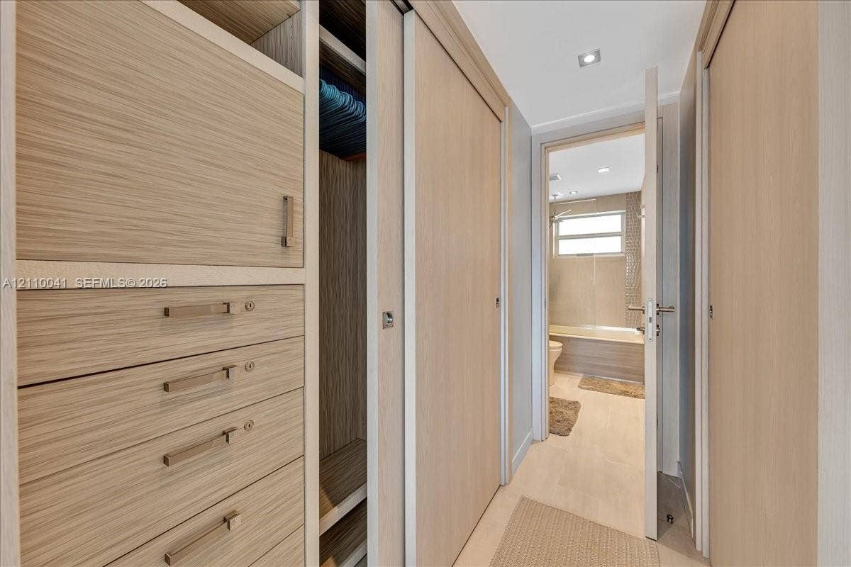 1610 Lenox Avenue, #516, Miami Beach, FL 33139 Built-in wood-finish cabinetry featuring integrated drawers, sliding closet doors, recessed ceiling lighting, and polished metal hardware