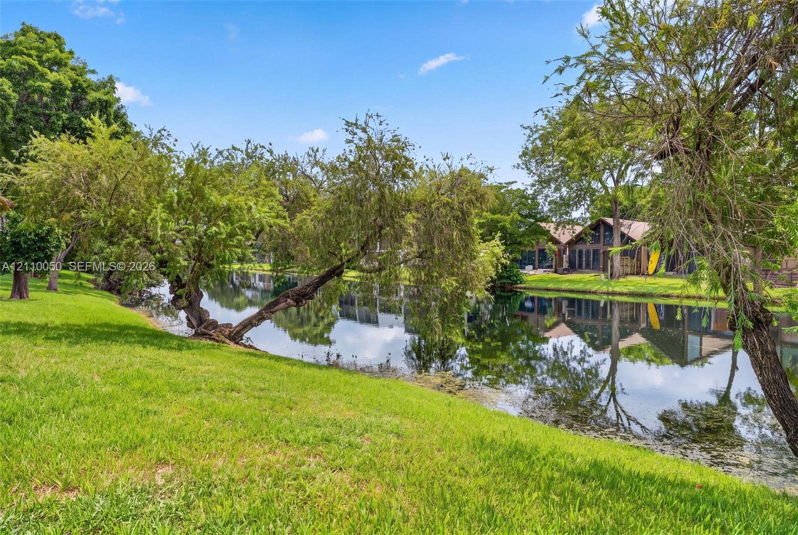 506 Westree Lane, Plantation, Plantation, FL 33324 Waterfront parcel featuring a manicured lawn, mature trees, and direct water access
