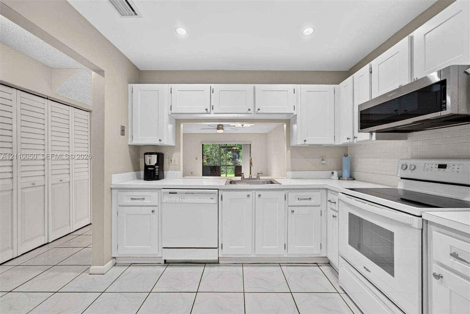 506 Westree Lane, Plantation, Plantation, FL 33324 Kitchen featuring white shaker-style cabinetry, solid-surface countertops, recessed lighting, tile flooring, and a passthrough window