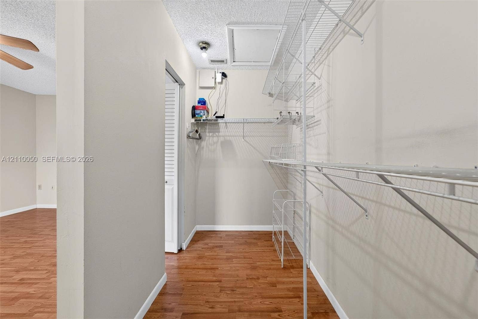 506 Westree Lane, Plantation, Plantation, FL 33324 Storage area featuring wood-finish flooring, white wire shelving, and a ceiling access panel