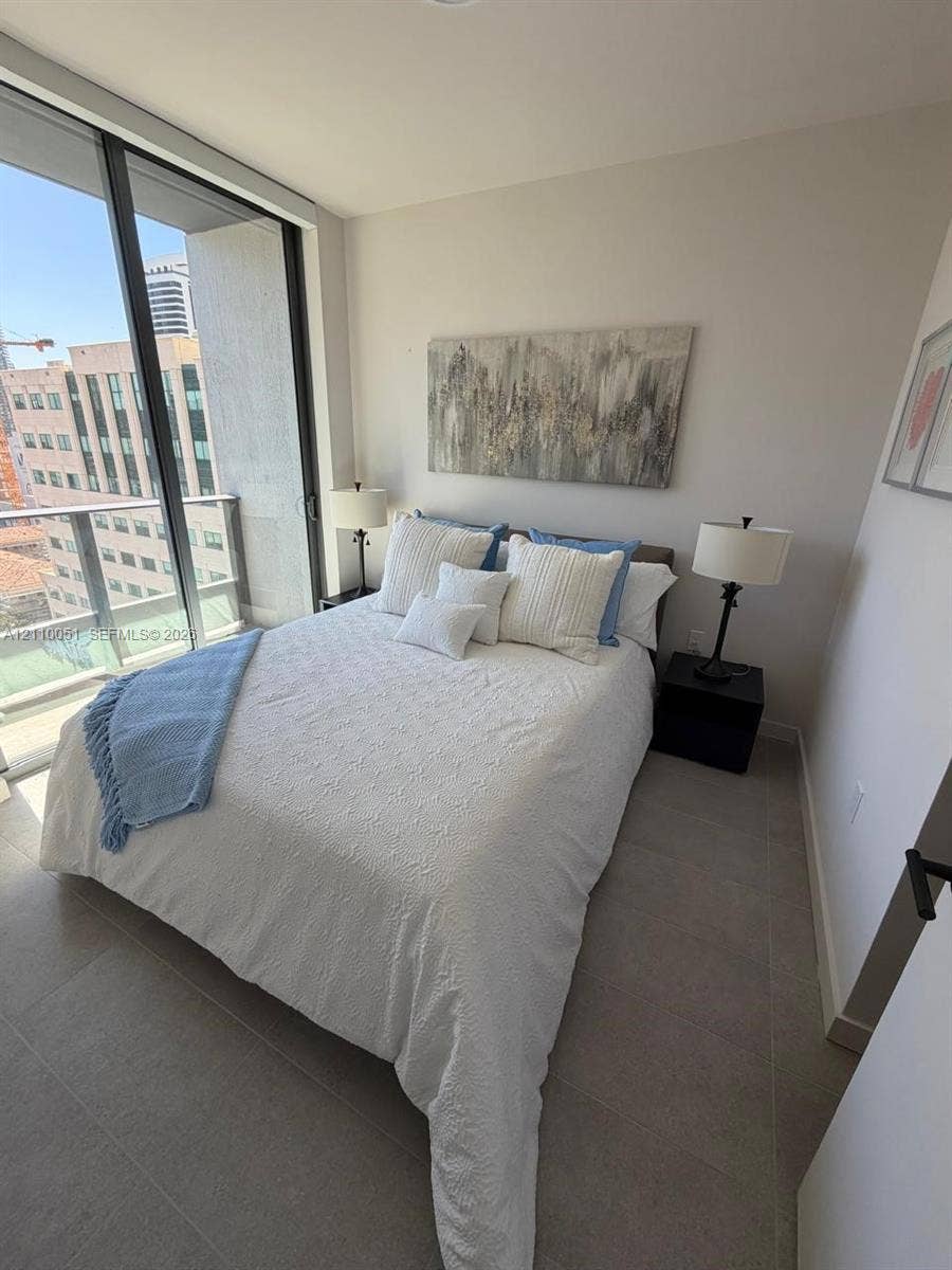 121 NE 5th Street, #1703, Miami, FL 33132 Floor-to-ceiling glass sliding door, balcony access, and large-format tile flooring