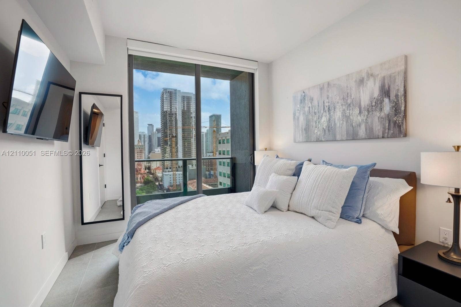 121 NE 5th Street, #1703, Miami, FL 33132 Floor-to-ceiling glass sliding door, Juliet balcony with metal railing, and large-format tile flooring