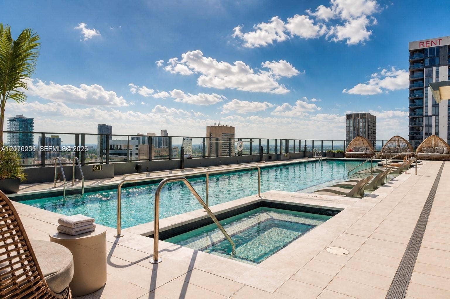 121 NE 5th Street, #1703, Miami, FL 33132 Rooftop swimming pool and spa featuring tiled decking, metal railing, and a city skyline backdrop
