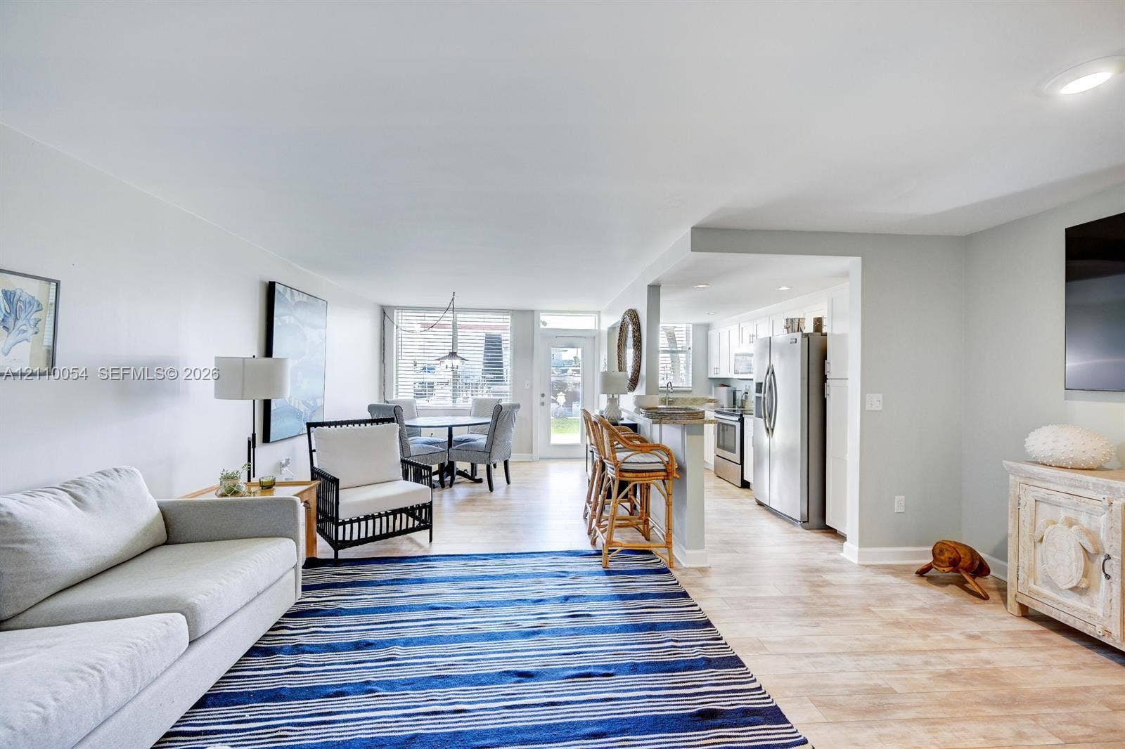 Open concept floor plan featuring recessed lighting, light wood-finish flooring, a kitchen breakfast bar, and stainless steel appliances