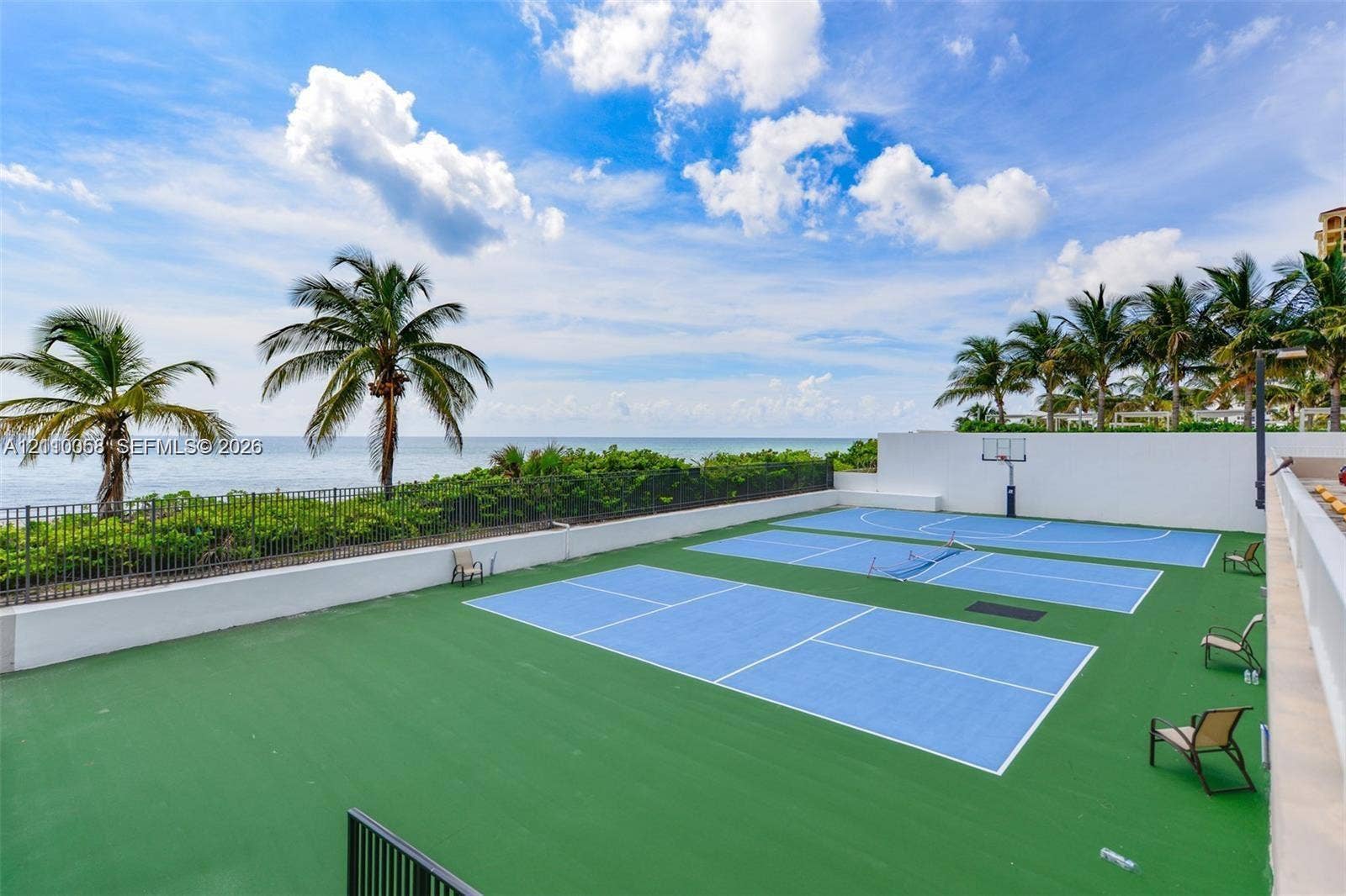 1950 S Ocean Drive, #3K, Hallandale Beach, Hallandale Beach, FL 33009 Multi-purpose sports court with integrated pickleball and basketball markings, enclosed by perimeter fencing, set against an oceanfront backdrop with mature palm trees