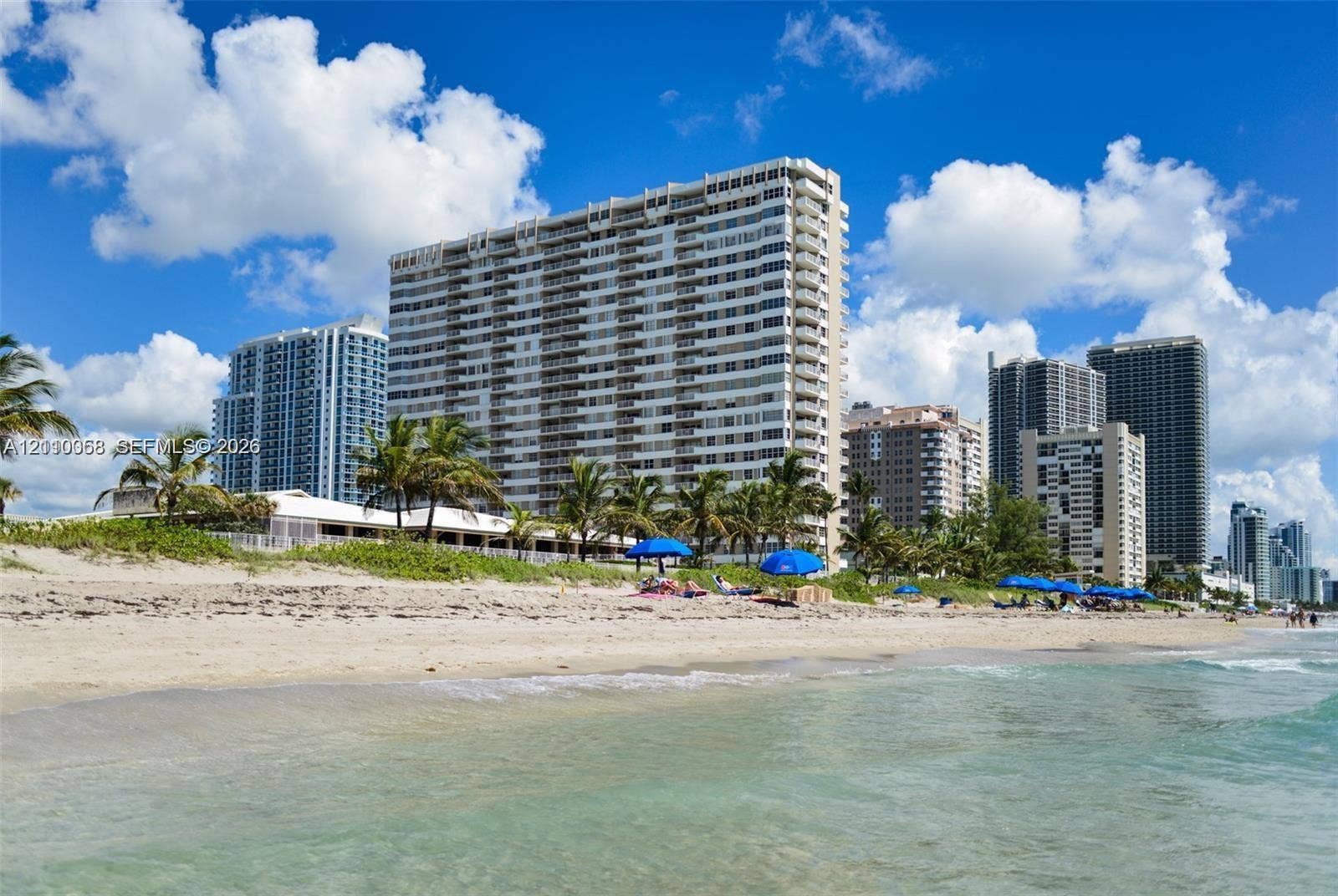 1950 S Ocean Drive, #3K, Hallandale Beach, Hallandale Beach, FL 33009 High-rise residential building featuring expansive glass-paneled balconies situated on a sand beach with direct shoreline access and native tropical landscaping