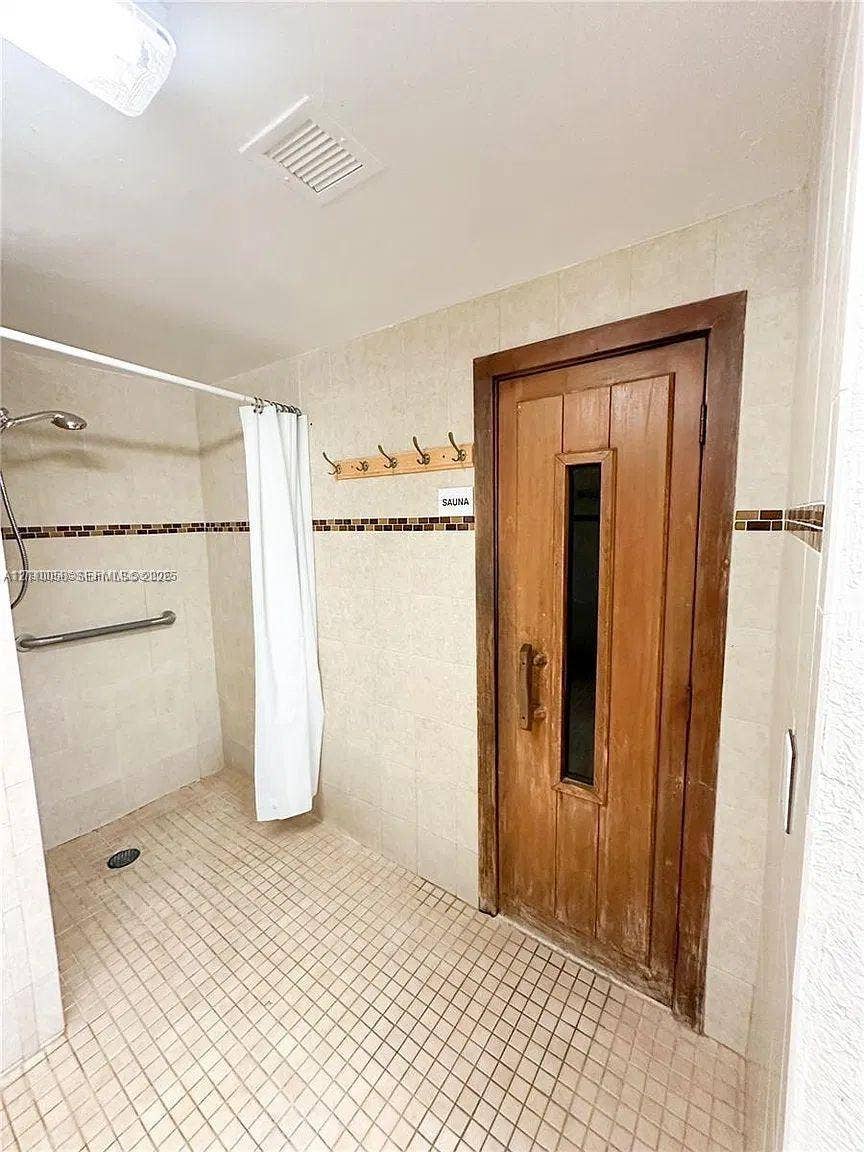 1950 S Ocean Drive, #3K, Hallandale Beach, Hallandale Beach, FL 33009 Walk-in shower with a wall-mounted grab bar, tile flooring, and integrated sauna with a wood door