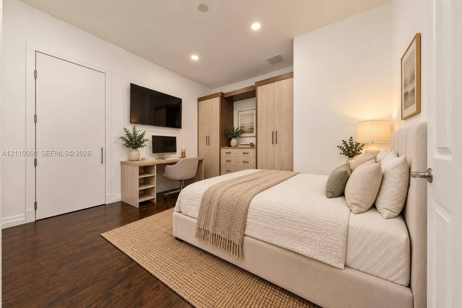 Virtually staged. Built-in light-tone wood cabinetry with integrated desk space, wood-finish flooring, and recessed ceiling lighting