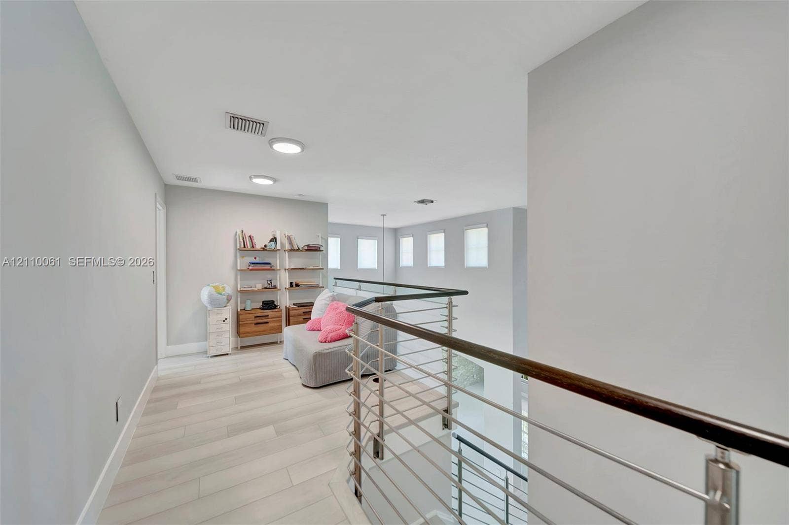 4424 E Whitewater Avenue, Weston, FL 33332 Open floor plan featuring wood-finish flooring, recessed lighting, and a metal horizontal-bar railing with a wood cap