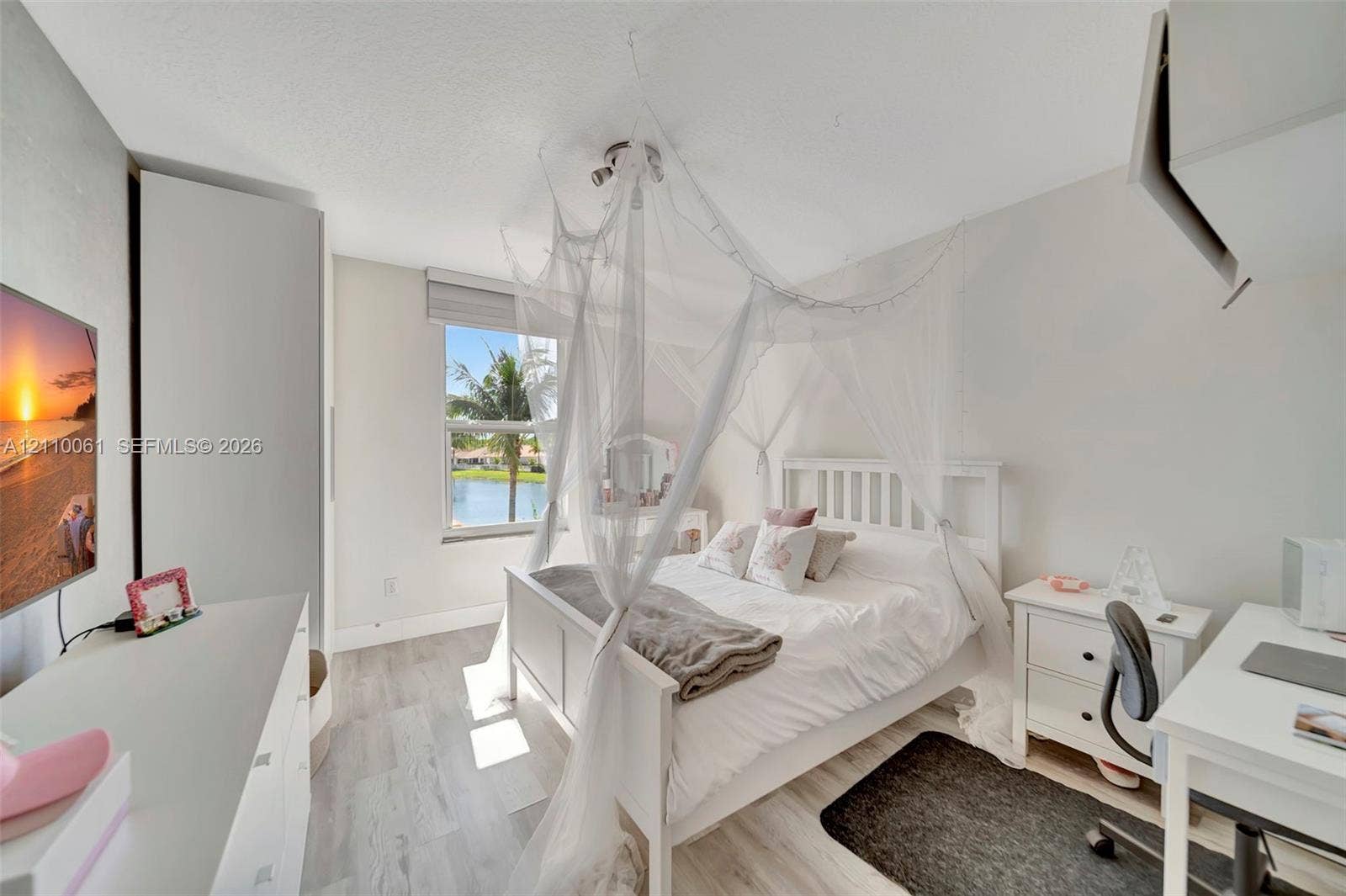 4424 E Whitewater Avenue, Weston, FL 33332 Light-filled room featuring wood-finish flooring, a neutral color palette, and a window overlooking a water feature