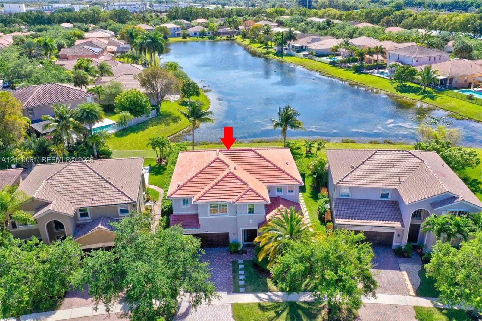 4424 E Whitewater Avenue, Weston, FL 33332 Two-story residence featuring a tile roof, paver driveway, and direct water frontage on a lake