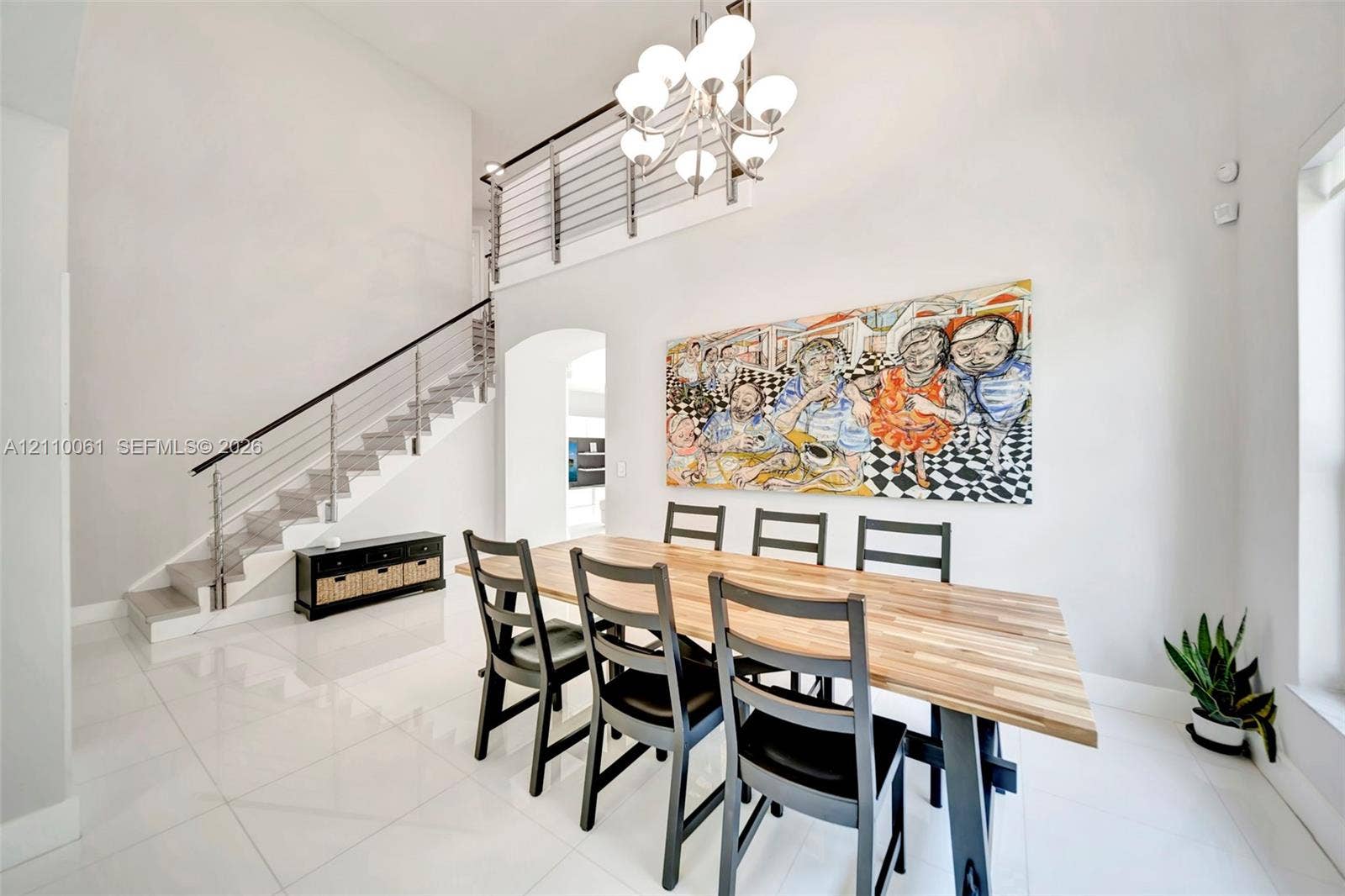 4424 E Whitewater Avenue, Weston, FL 33332 High-ceilinged room featuring large-format tile flooring, a multi-globe chandelier, and an open staircase with a metal cable railing system