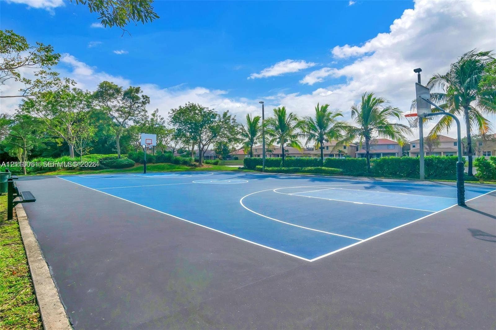 4424 E Whitewater Avenue, Weston, FL 33332 Hard-surface outdoor basketball court featuring painted boundary lines, dual hoops, and integrated lighting fixtures surrounded by landscaping