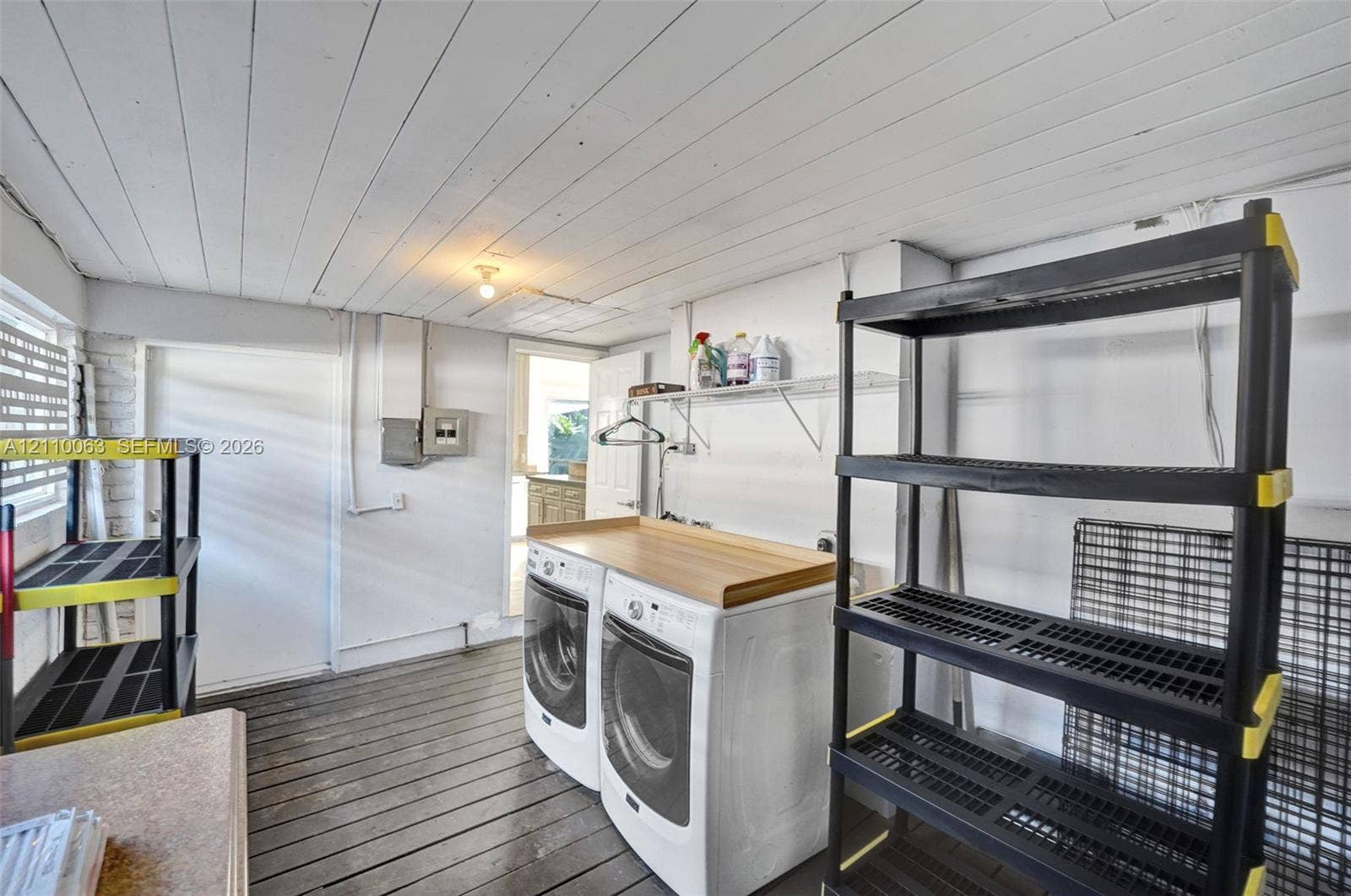 Laundry area featuring a wood-plank ceiling, wood-finish flooring, and wall-mounted shelving