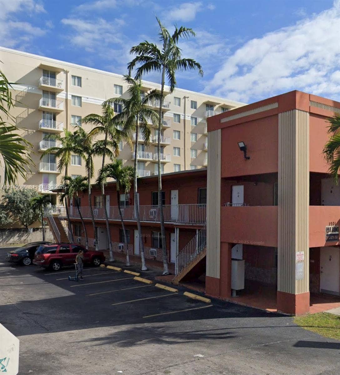 1701 NW 27th Avenue, #14, Miami, Miami, FL 33125 Two-story exterior with stucco finish, integrated outdoor staircase, metal railings, and dedicated asphalt parking