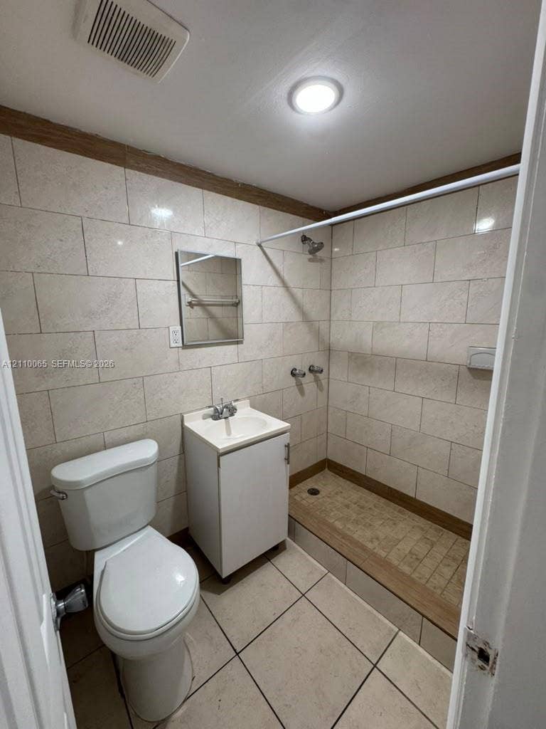 1701 NW 27th Avenue, #14, Miami, Miami, FL 33125 Full-height, large-format tile wall cladding, walk-in shower with integrated threshold, pedestal-style vanity with single-basin sink, and neutral ceramic tile flooring