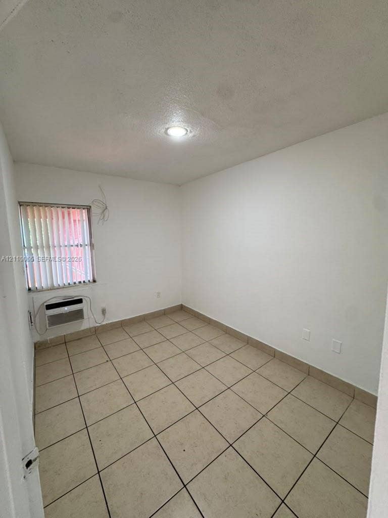 1701 NW 27th Avenue, #14, Miami, Miami, FL 33125 Room featuring neutral tile flooring, recessed ceiling lighting, and a wall-mounted climate control unit