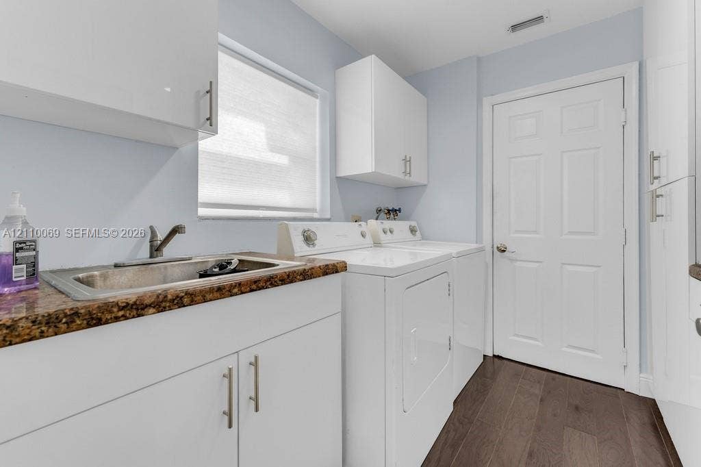 4325 NW 95th Terrace, Sunrise, FL 33351 Laundry room featuring high-gloss white cabinetry, a stone-patterned countertop, an integrated stainless steel sink with a high-arch faucet, and wood-finish flooring