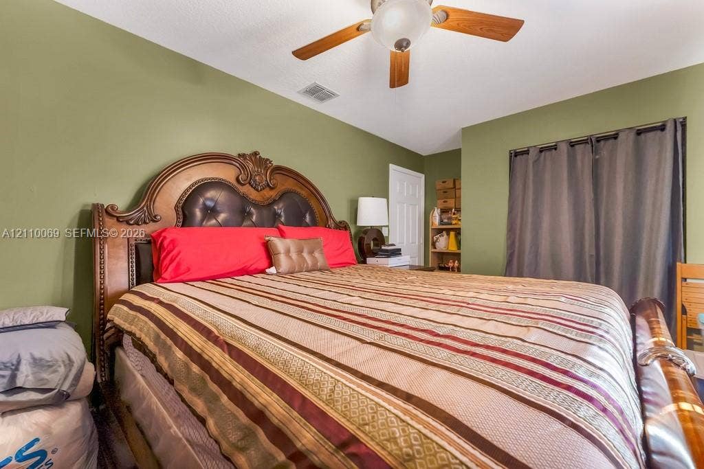 4325 NW 95th Terrace, Sunrise, FL 33351 Bedroom featuring a multi-blade ceiling fan with an integrated light fixture and a multi-panel interior door
