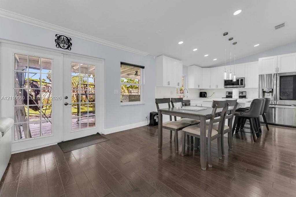 4325 NW 95th Terrace, Sunrise, FL 33351 Kitchen featuring white shaker cabinetry, stainless steel appliances, recessed lighting, and wood-finish flooring with dual-pane French doors