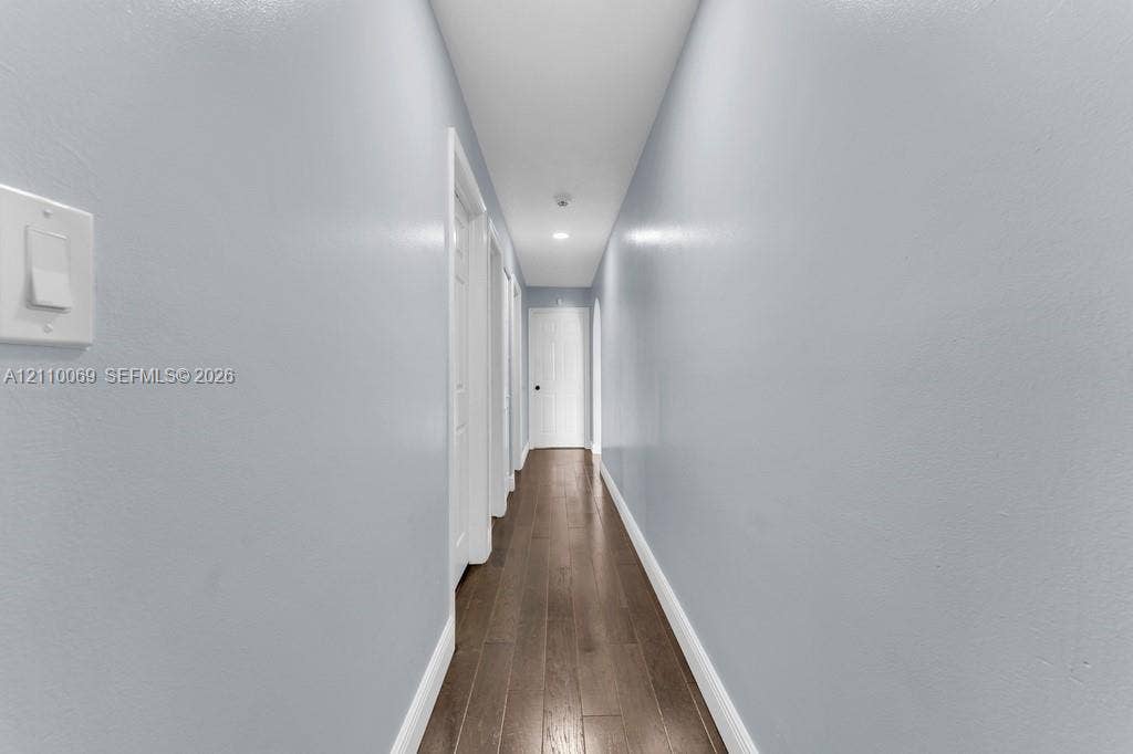 4325 NW 95th Terrace, Sunrise, FL 33351 Hallway featuring wood-finish flooring, recessed lighting, and multiple interior paneled doors