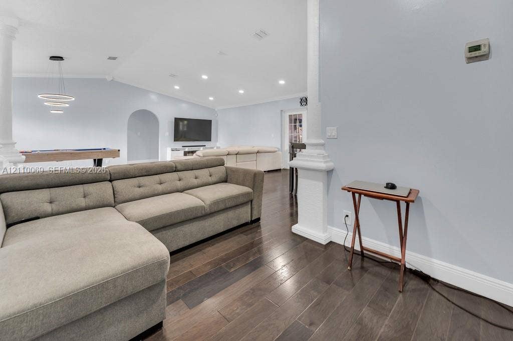 4325 NW 95th Terrace, Sunrise, FL 33351 Open-concept room featuring wood-finish flooring, recessed lighting, architectural columns, and a rounded archway