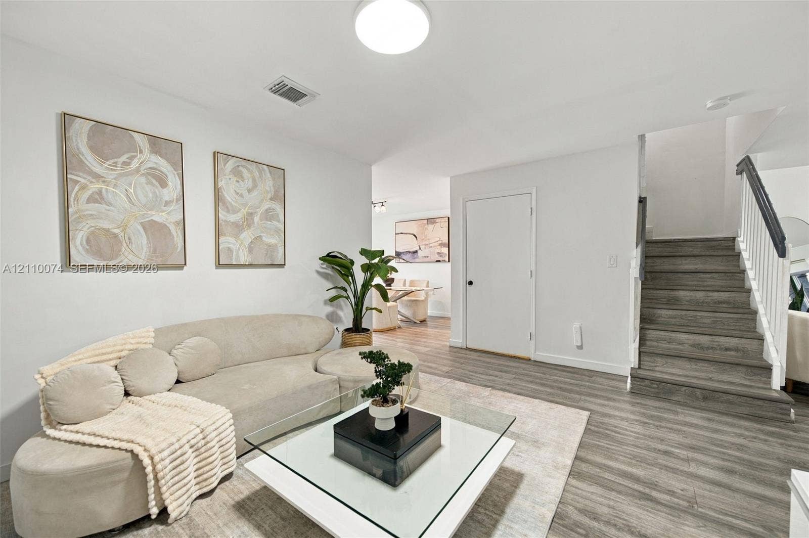 17370 NW 69th Court, #304, Hialeah, FL 33015 Interior featuring wood-finish flooring, staircase with a white balustrade, and a flush-mount ceiling fixture