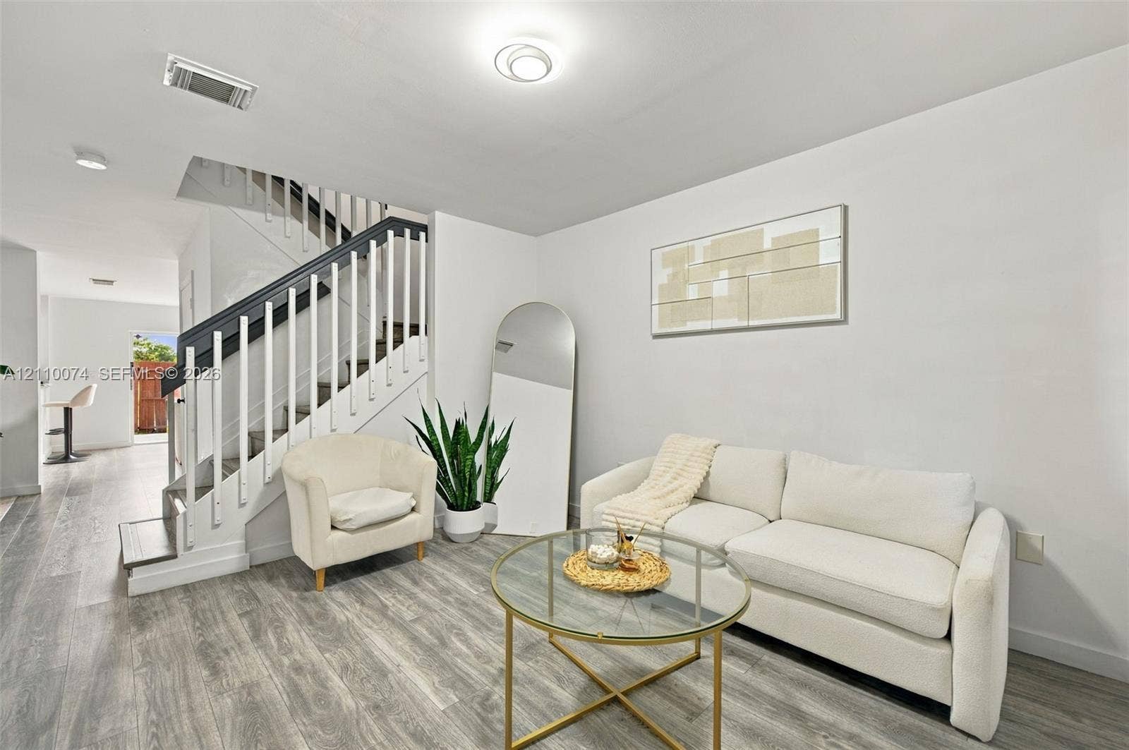 17370 NW 69th Court, #304, Hialeah, FL 33015 Staircase featuring white balusters with dark-toned handrails, wood-finish flooring, and recessed ceiling lighting