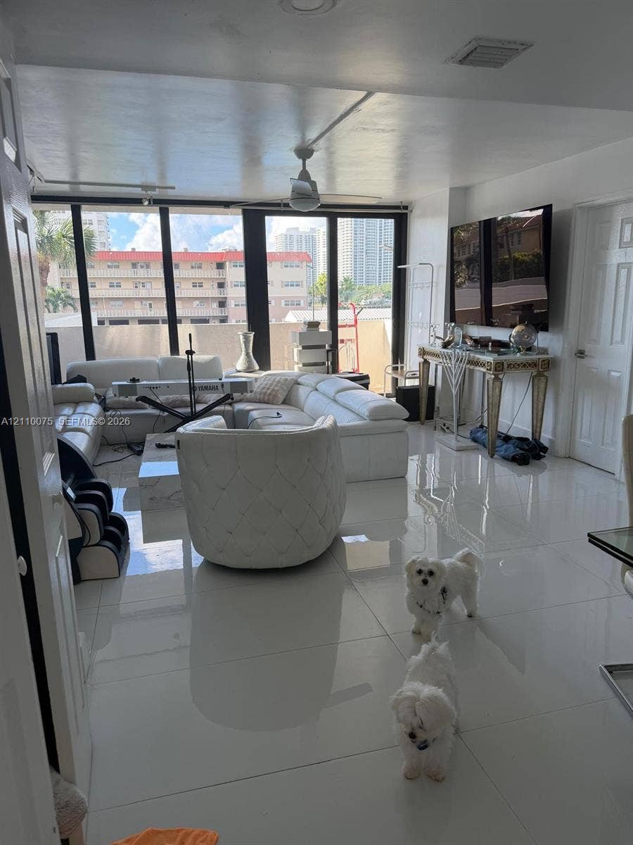 2017 S Ocean Drive, #208, Hallandale Beach, Hallandale Beach, FL 33009 Open-concept interior featuring large-format polished tile flooring, expansive floor-to-ceiling windows, and a central ceiling fan