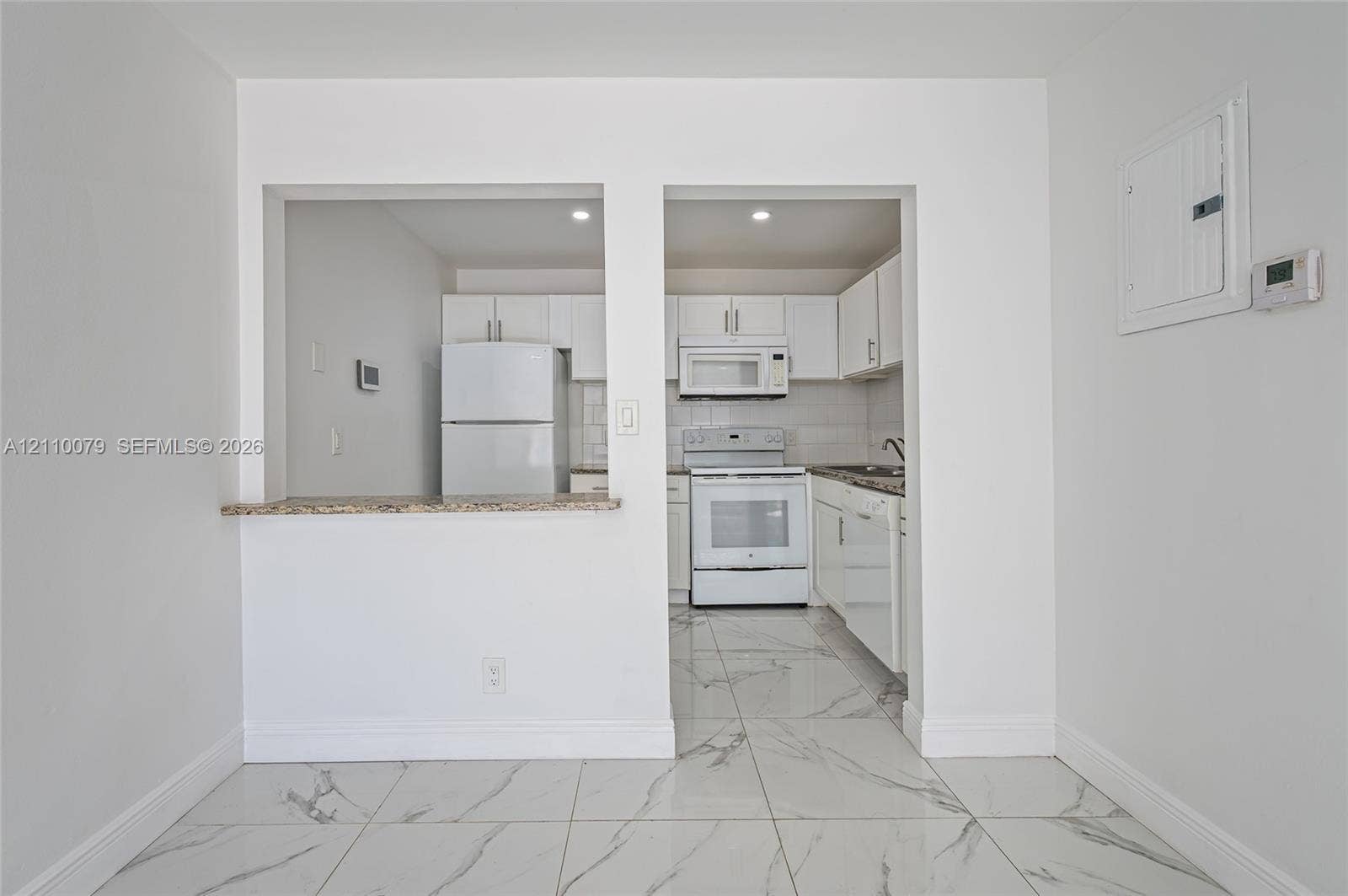 4106 NW 88th Avenue, #3, Coral Springs, FL 33065 Kitchen featuring white cabinetry, stone-finish countertops, tile flooring, and integrated white appliances