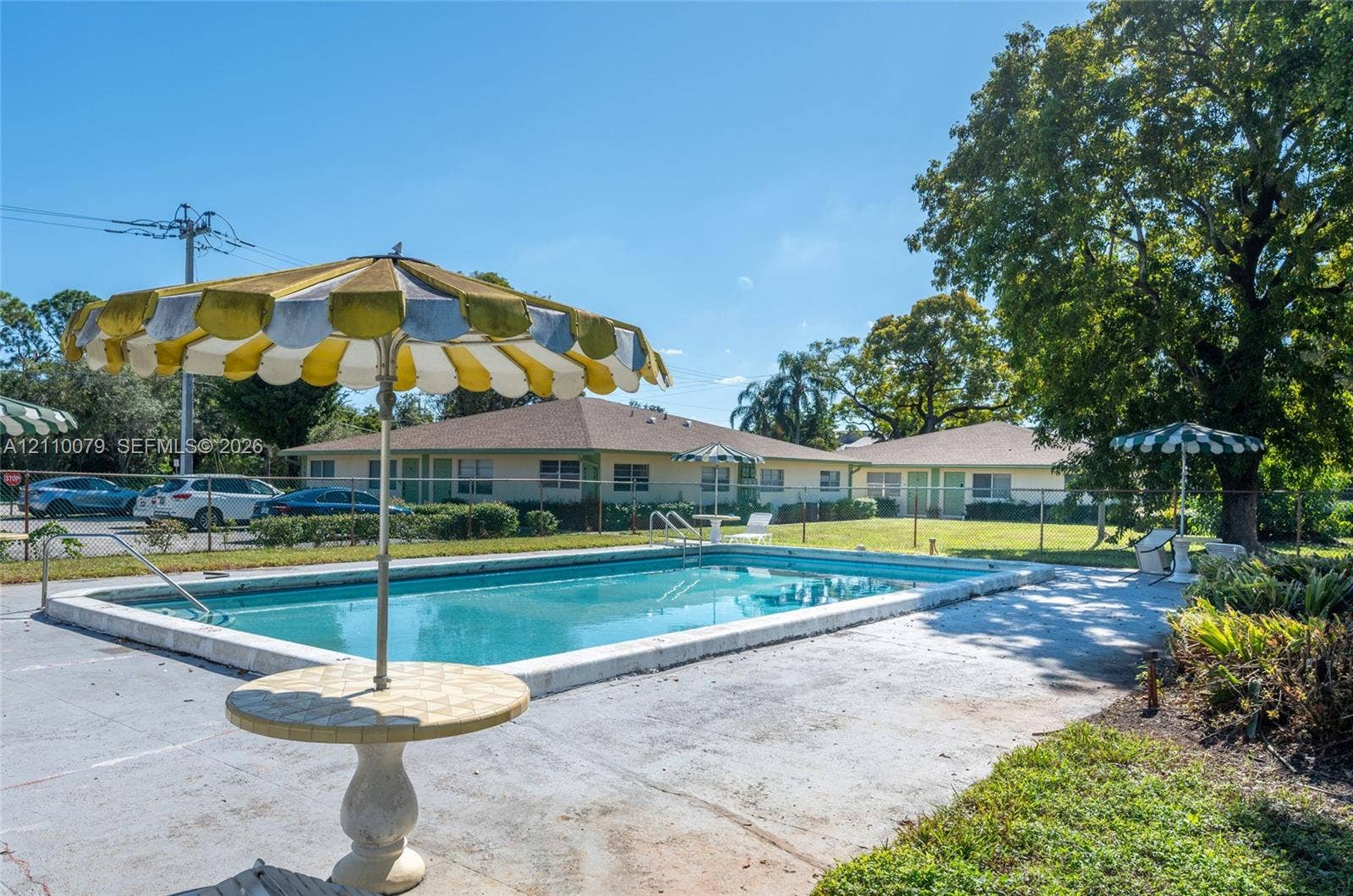 4106 NW 88th Avenue, #3, Coral Springs, FL 33065 In-ground swimming pool with a concrete deck, enclosed by perimeter fencing and surrounded by mature trees