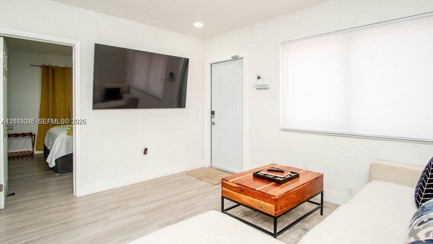 7815 NW 5th Court, #1, Miami, Miami, FL 33150 Interior featuring neutral wall tones, wood-finish flooring, recessed lighting, and a large horizontal window with fitted blinds
