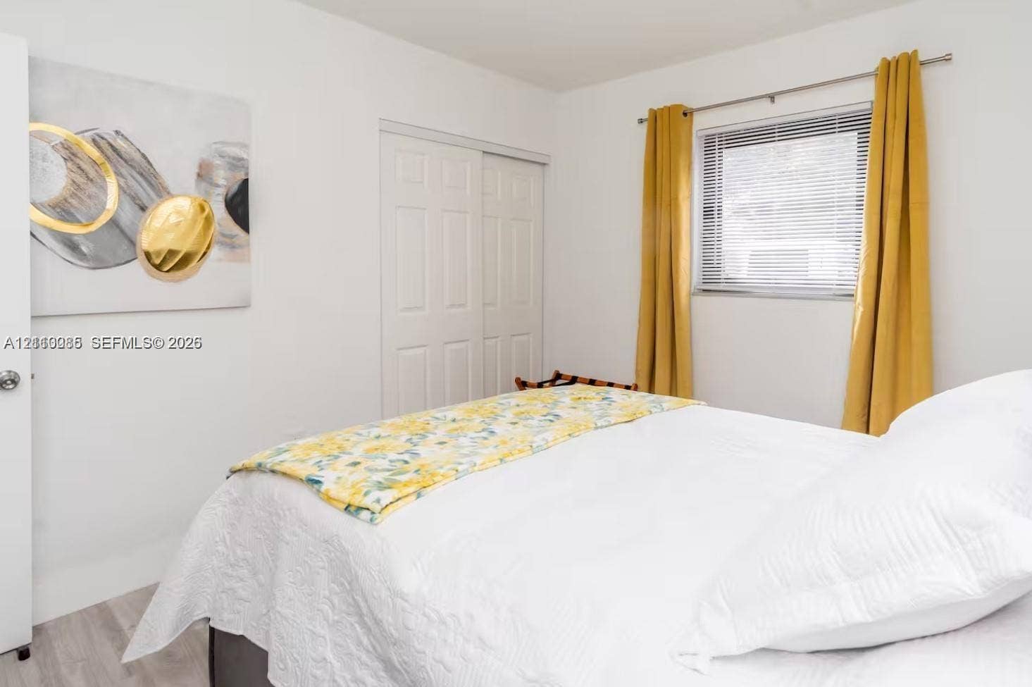 7815 NW 5th Court, #1, Miami, Miami, FL 33150 Bedroom featuring light-toned wood-finish flooring, a double-panel sliding closet door, and a horizontal window with adjustable metal blinds