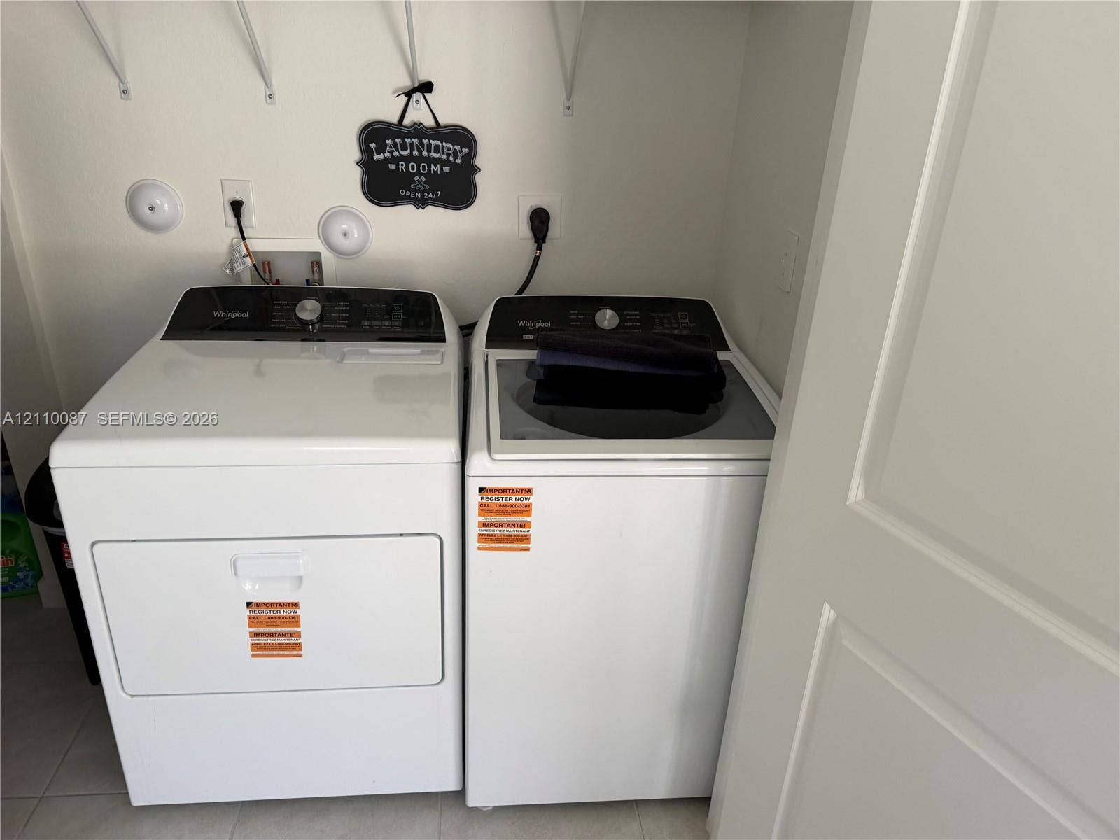 1358 NE 3rd Avenue, #1, Florida City, Florida City, FL 33034 Utility area featuring side-by-side white clothes washer and dryer units, integrated utility hookups, and overhead wall-mounted shelving