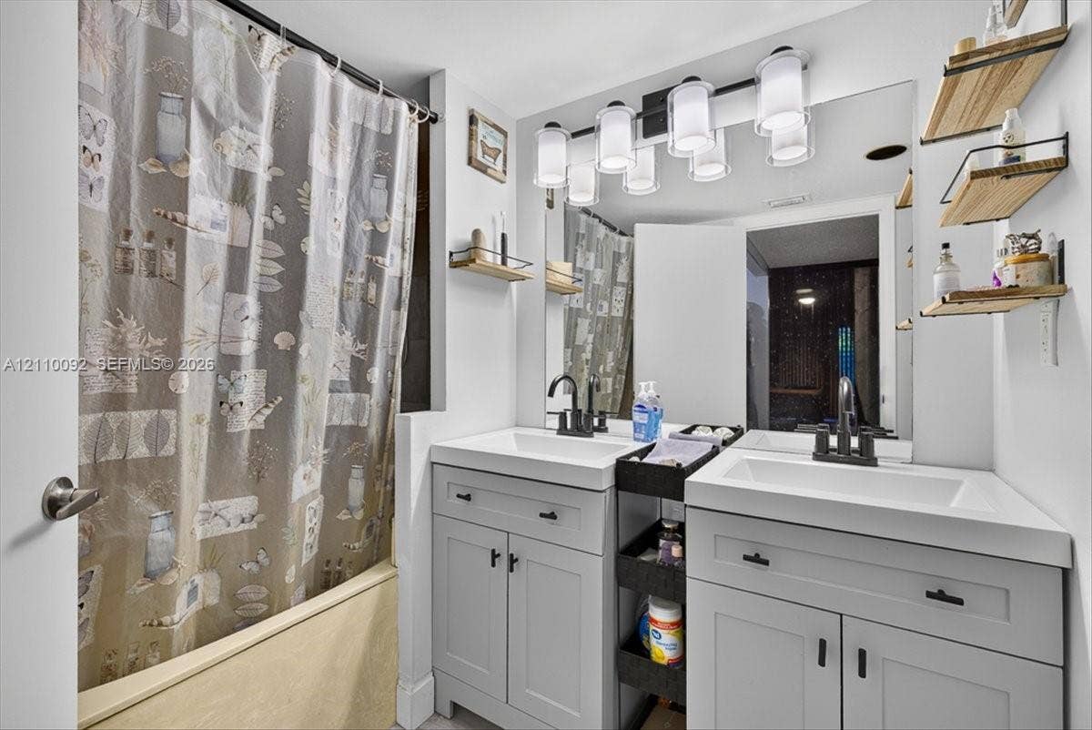 1403 SW 110th Way, Davie, FL 33324 Double vanity featuring gray Shaker-style cabinetry, white integrated rectangular sinks, matte black faucets, and a five-light vanity fixture