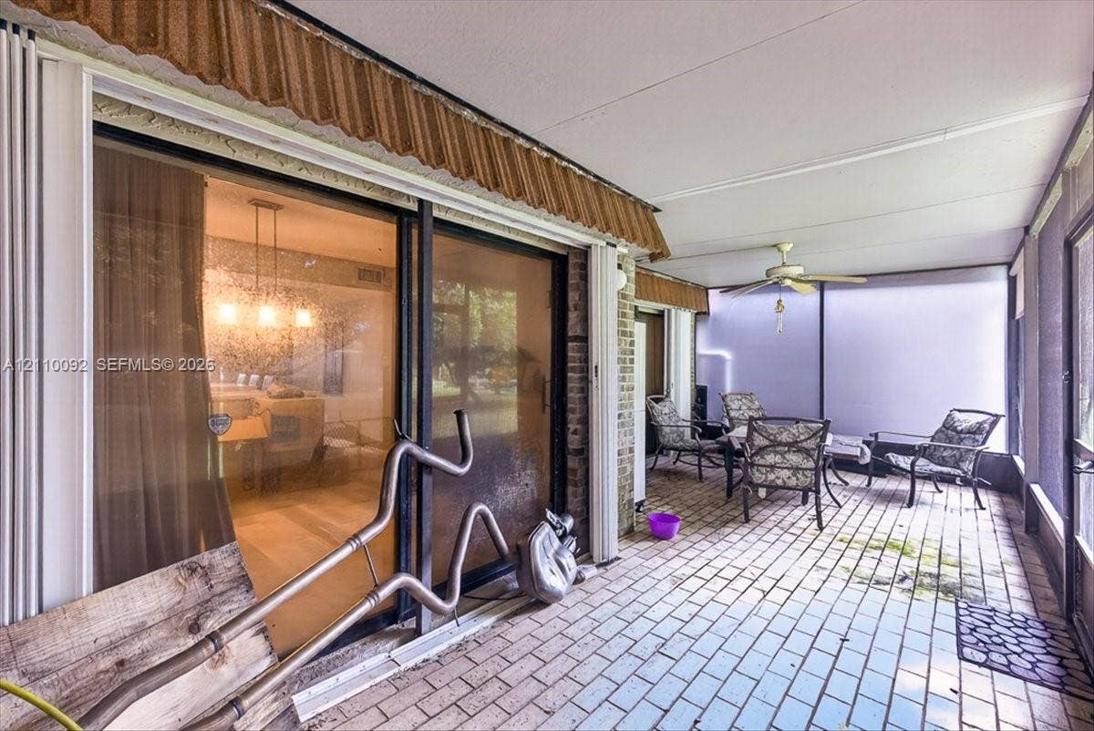1403 SW 110th Way, Davie, FL 33324 Enclosed patio featuring brick-style flooring, a ceiling fan, and sliding glass door entry