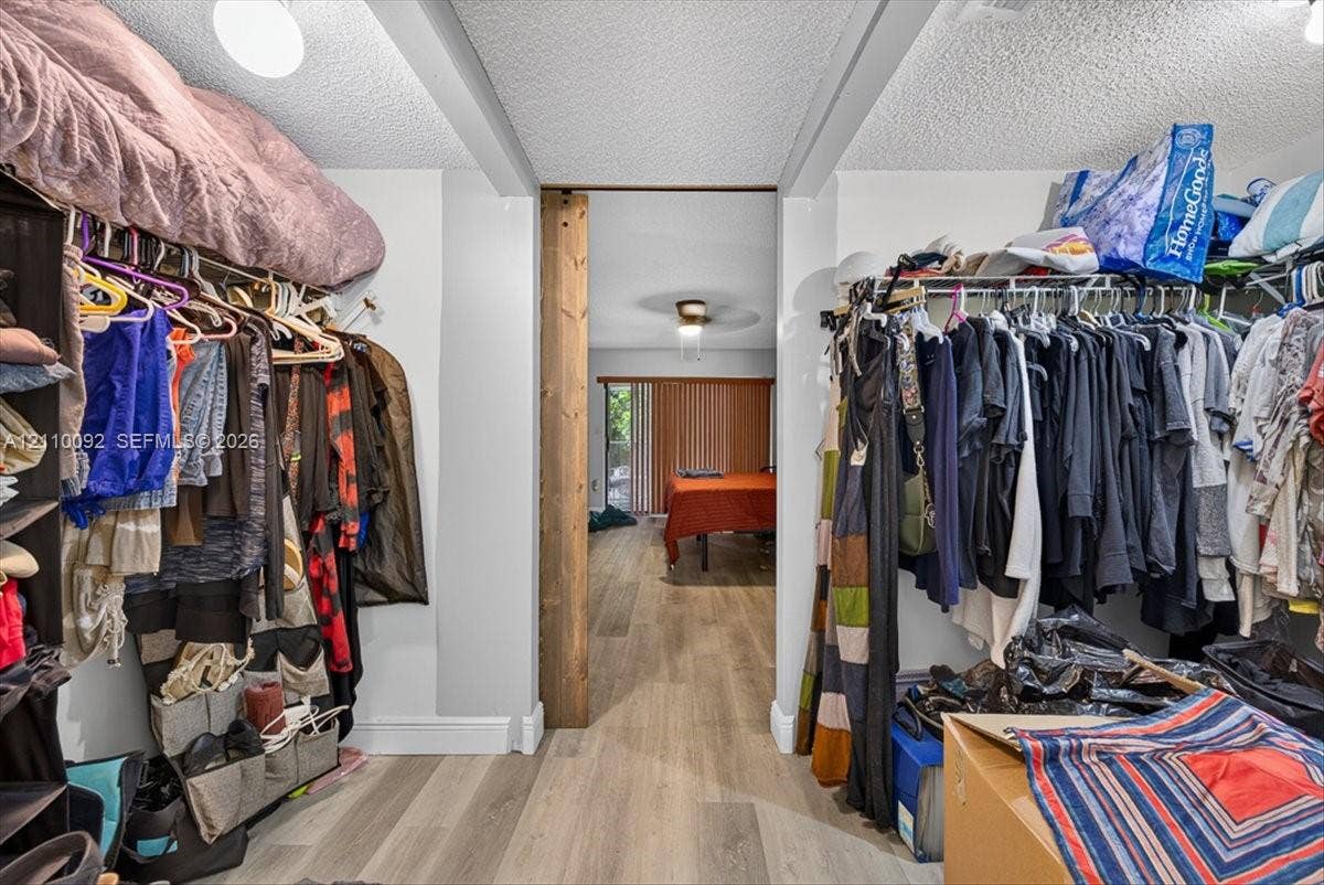 1403 SW 110th Way, Davie, FL 33324 Walk-in storage space featuring built-in wire shelving, wood-finish flooring, and a rustic wood-trimmed doorway