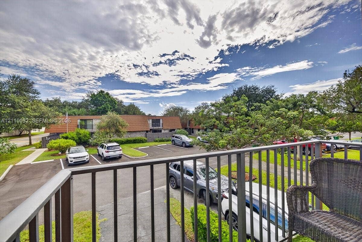 1403 SW 110th Way, Davie, FL 33324 Elevated balcony with vertical metal railing overlooking the parking area and landscape