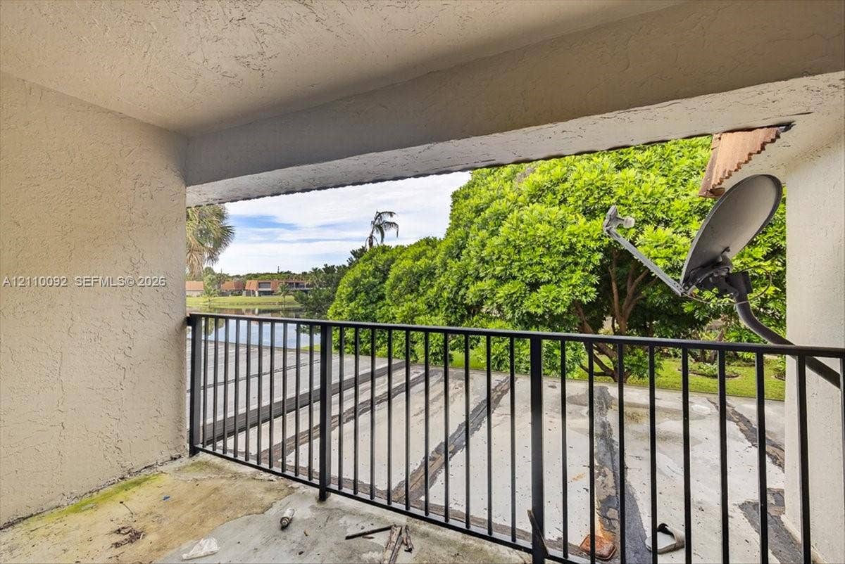 1403 SW 110th Way, Davie, FL 33324 Covered balcony featuring concrete flooring and black metal railing