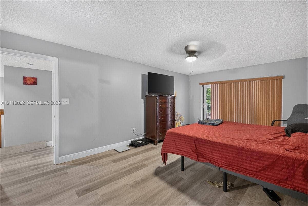 1403 SW 110th Way, Davie, FL 33324 Wood-finish flooring, ceiling fan with integrated lighting, and vertical window blinds